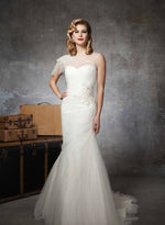 Justin Alexander 8651 has an illusion bateau neckline with a jeweled shoulder and flutter cap sleeve on a tulle ruched mermaid. Beading at the hip into a dropped waist and a chapel length train. Buttons cover the back zipper to the dropped waist.