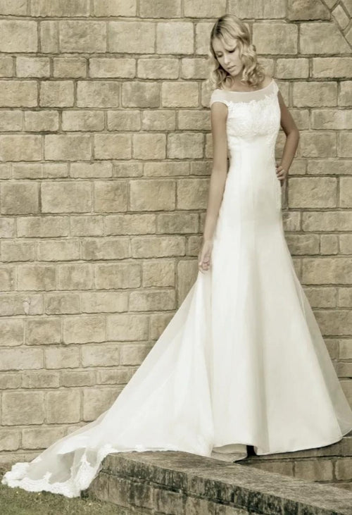 Augusta Jones Tippi is an a-line, mikado bridal gown with a soft sweetheart neckline, a chapel train and button detailing