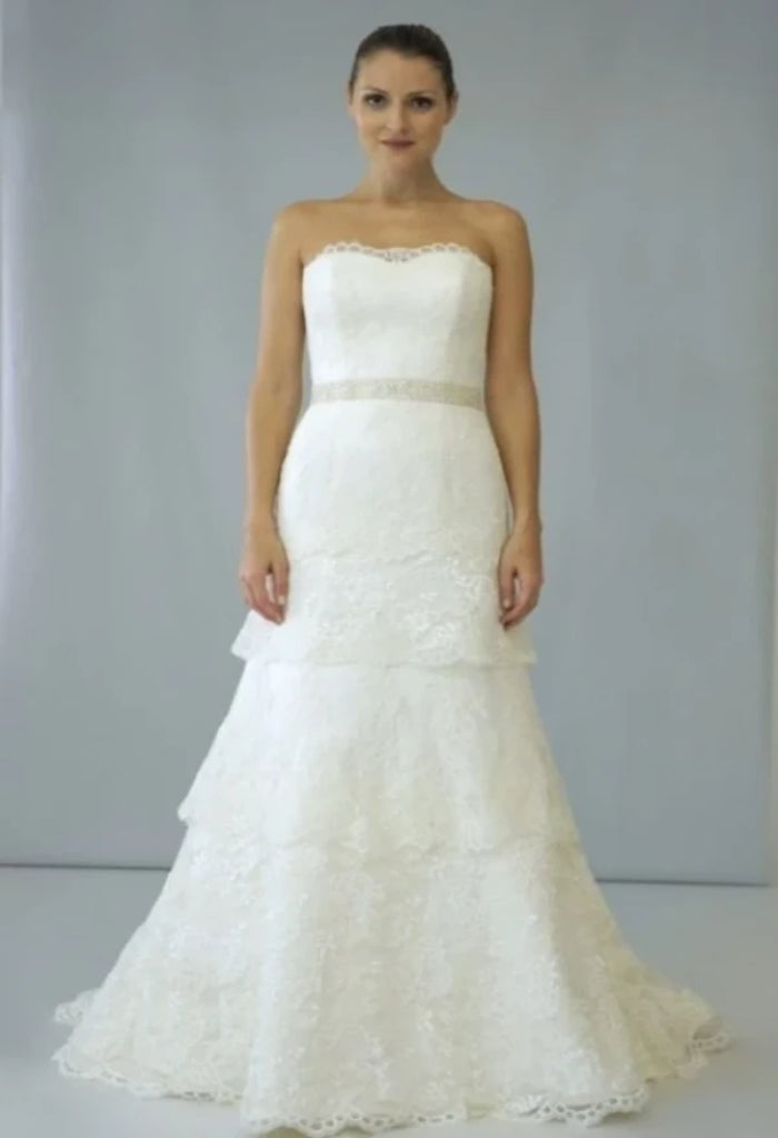 Augusta Jones Bell is an elegant a-line, lace bridal gown featuring all over ivory lace, a sweetheart neckline and a beautiful tiered, chapel length skirt