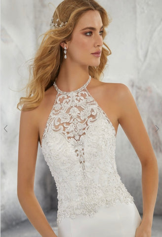 morilee halter neck wedding dress We love this Mori Lee sleek fit and flare wedding dress has a collar-style halter neckline with an open back featuring crystal and pearl chandelier beading in crepe back satin