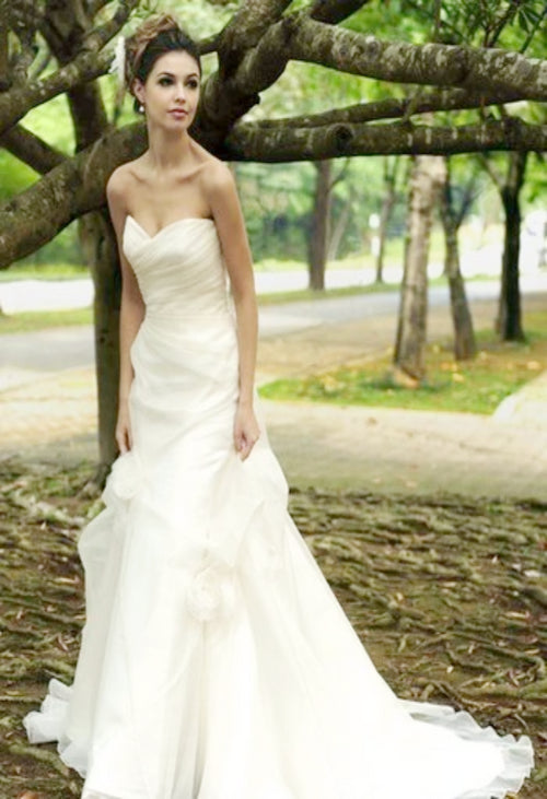 Augusta Jones Tina is an a-line, strapless, rouched body, organza wedding gown. It boasts a beautiful sweetheart neckline and a dramatic chapel train.