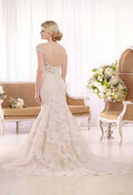 Essense of Australia D2002 this mermaid wedding gown features beaded lace and tulle over a sweetheart neckline and lace cap sleeves. From the back the dress features a low sheer, peek-a-boo, beaded and lace back with crystal buttons over the zip closure and a chapel length train