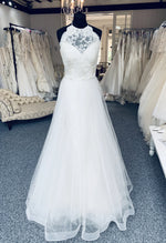 Tara Keely by Lazaro, style 2305 is a lace and tulle bridal gown with a lace halter neck. Size 8. New condition