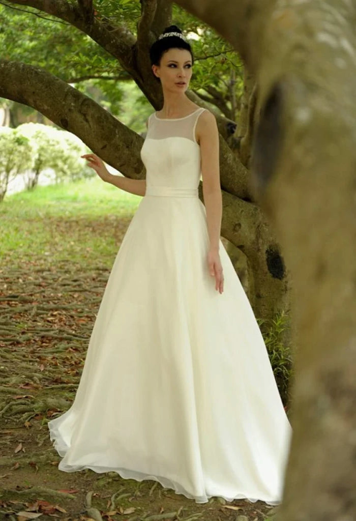 Augusta Jones Marilyn is a gorgeous figure flattering, a-line silhouette, organza and satin bridal gown. It boasts an camisole sweetheart neckline and an illusion back with covered button details